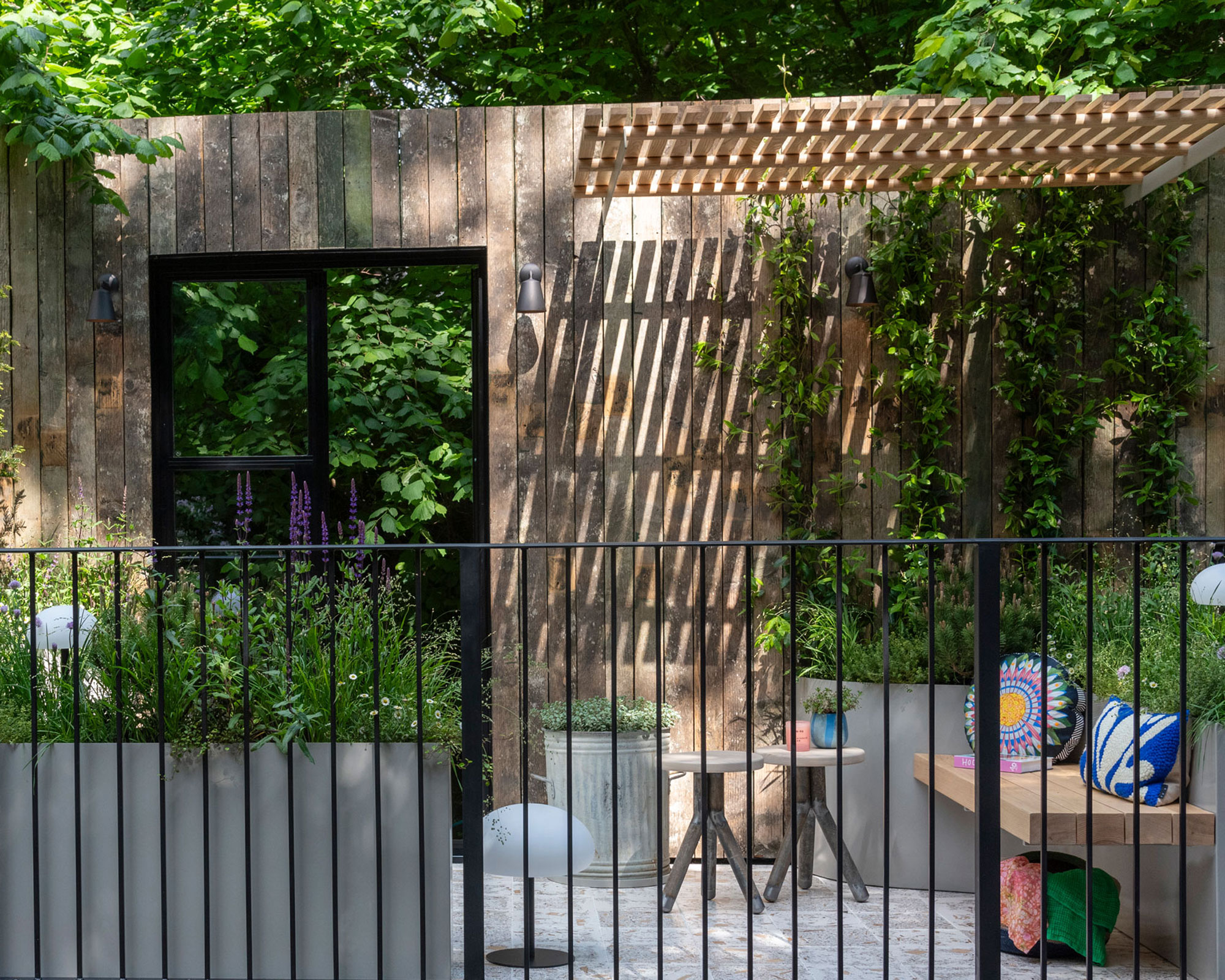small front yard with patio area with bench and small garden table, with slatted wooden cover and door