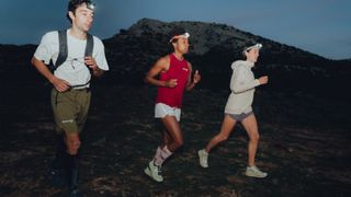 Group of runners in the dark wearing headtorches