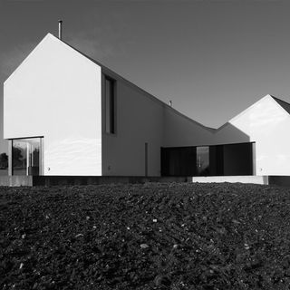 sloping roof house with white walls and grey land