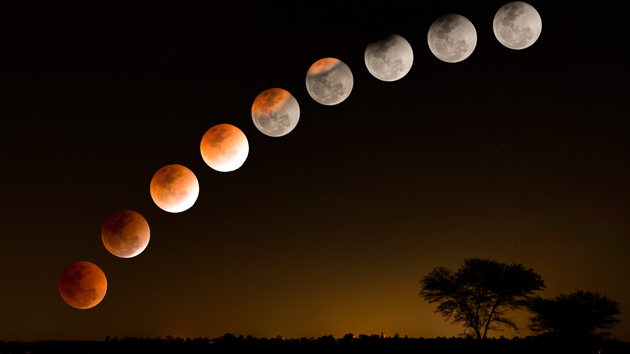 phases of a total lunar eclipse above the countryside