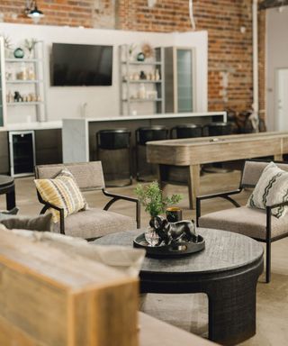 An industrial-style living room with dark materials and a kitchen bar area