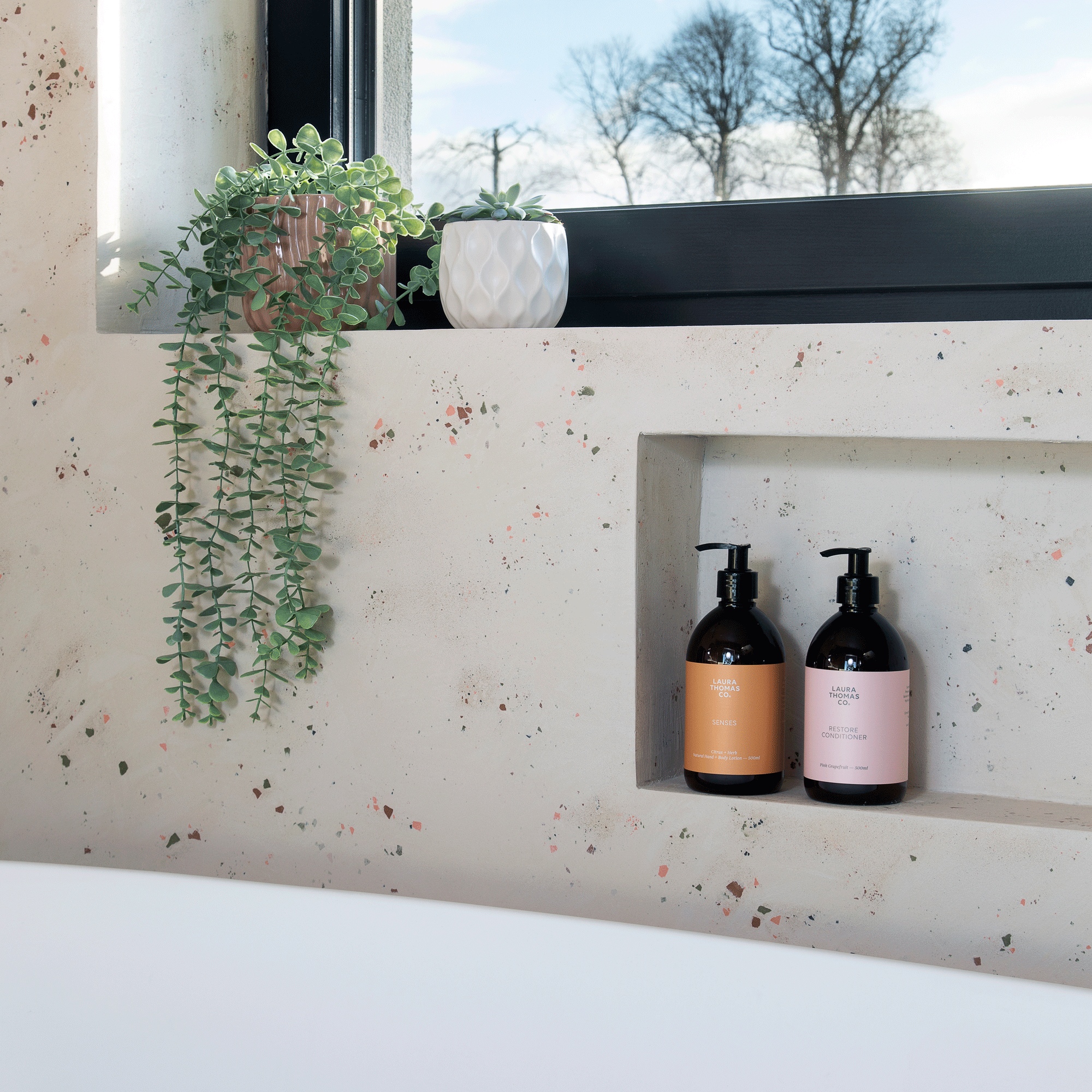a bathroom with a contemporary bath tub and a cubby shelf with two matching toiletries