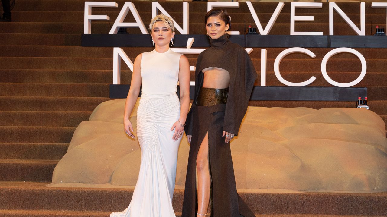 Florence Pugh and Zendaya at Dune photocall. Florence wears a white gown and Zendaya wears a brown two piece. 