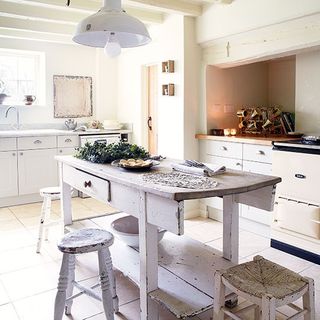white kitchen with table and drawers