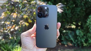 Jemand hält das Apple iPhone 14 Pro in der Hand und zeigt die Rückseite