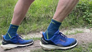 The reviewer wearing the Darn Tough Quarter Midweight Hiking Sock with Cushion in an active running pose