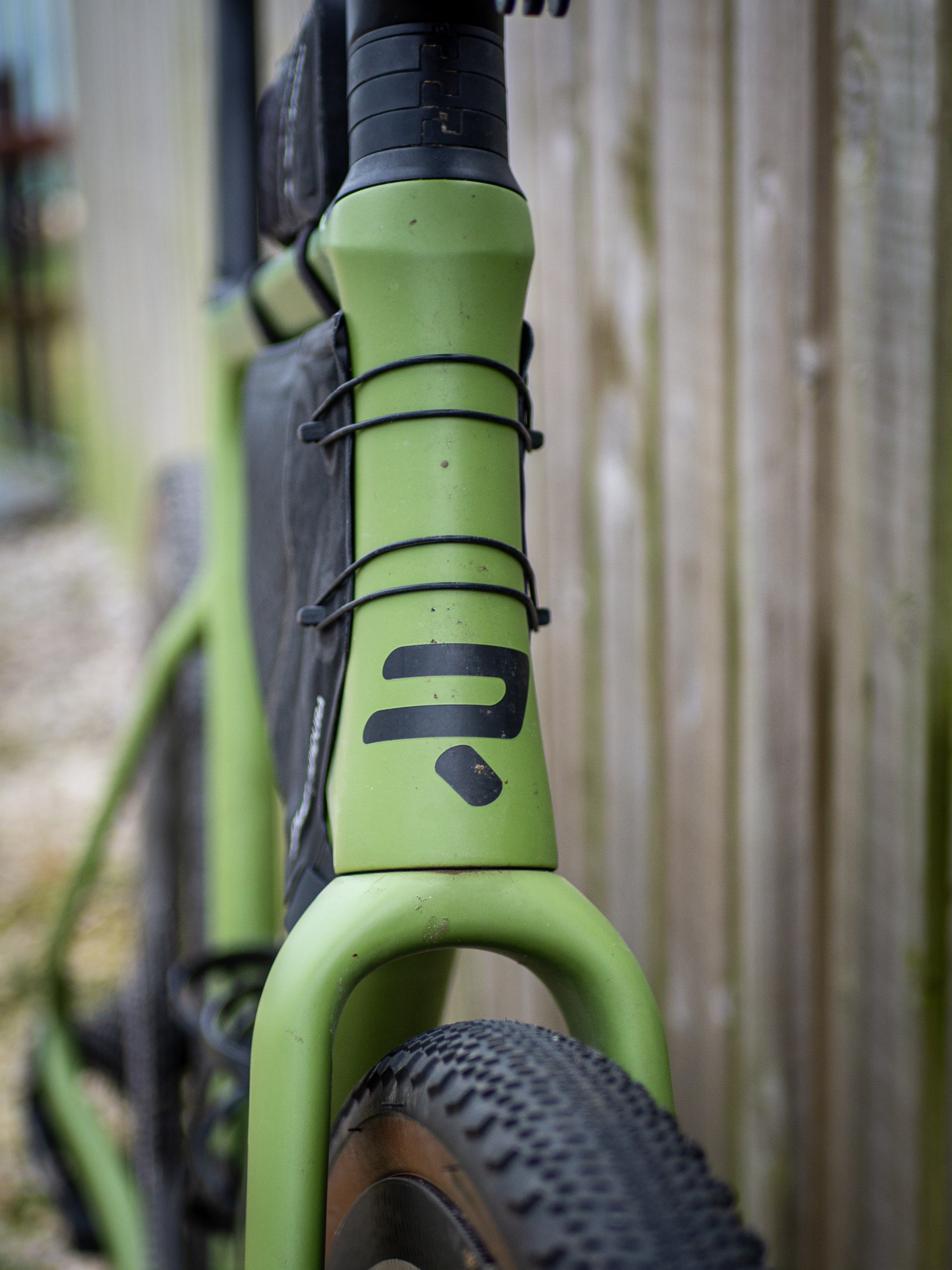 Detail photo of a green Ridley ASTR RS leaning against a wooden fence