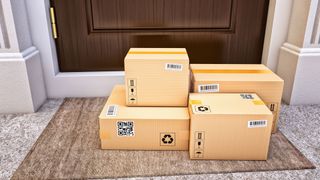 Four packages on a doormat outside a house, with the door closed.