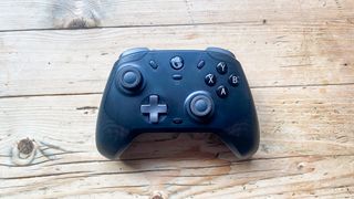 A black GameSir T4 Cyclone Pro controller sitting on a wooden desk