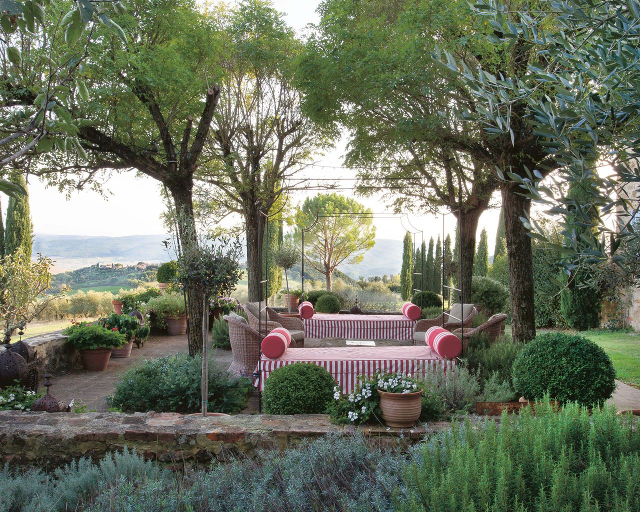 a Tuscan garden with red stripe daybed from A House Party in Tuscany Thames &amp; Hudson 