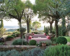 a Tuscan garden with red stripe daybed from A House Party in Tuscany Thames & Hudson 