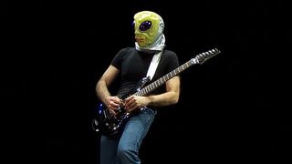 Joe Satriani wearing an alien mask