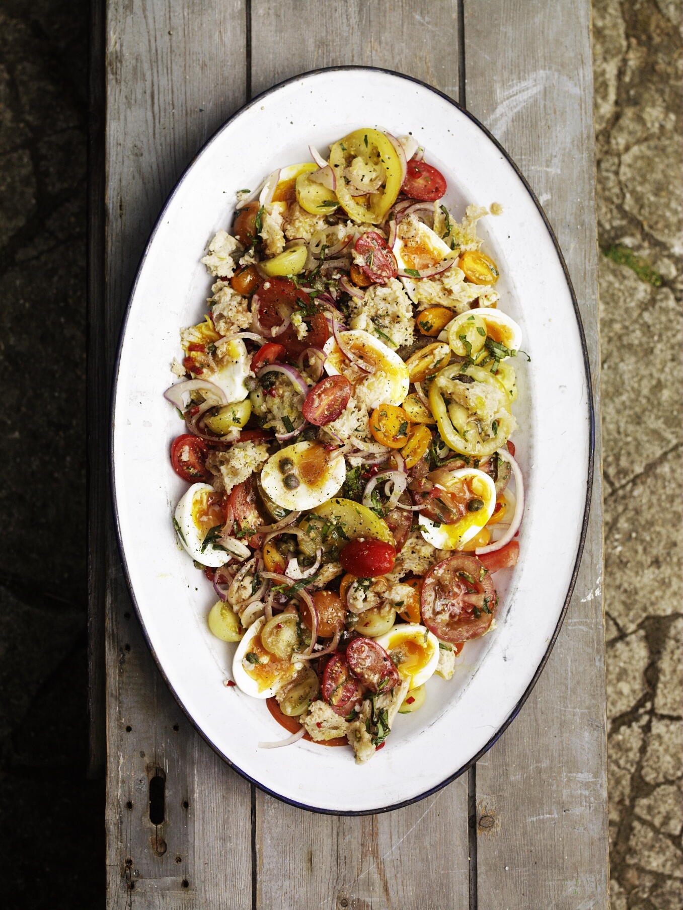A tomato, egg and caper salad on an oval serving dish