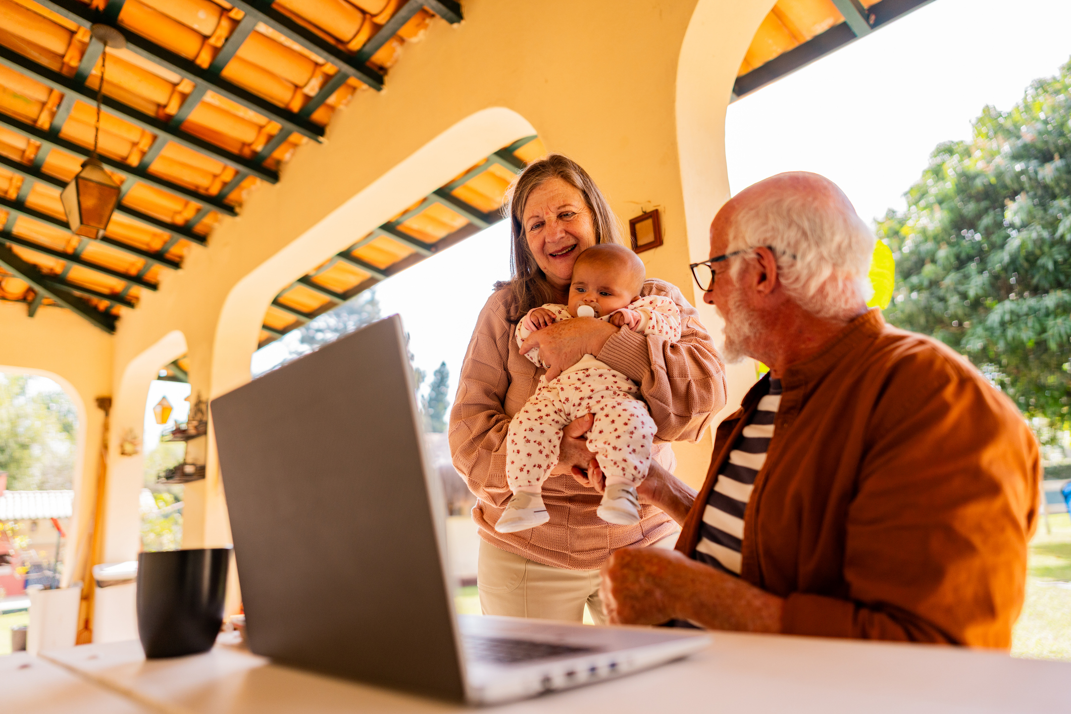 Grandparents with grandchild by a laptop