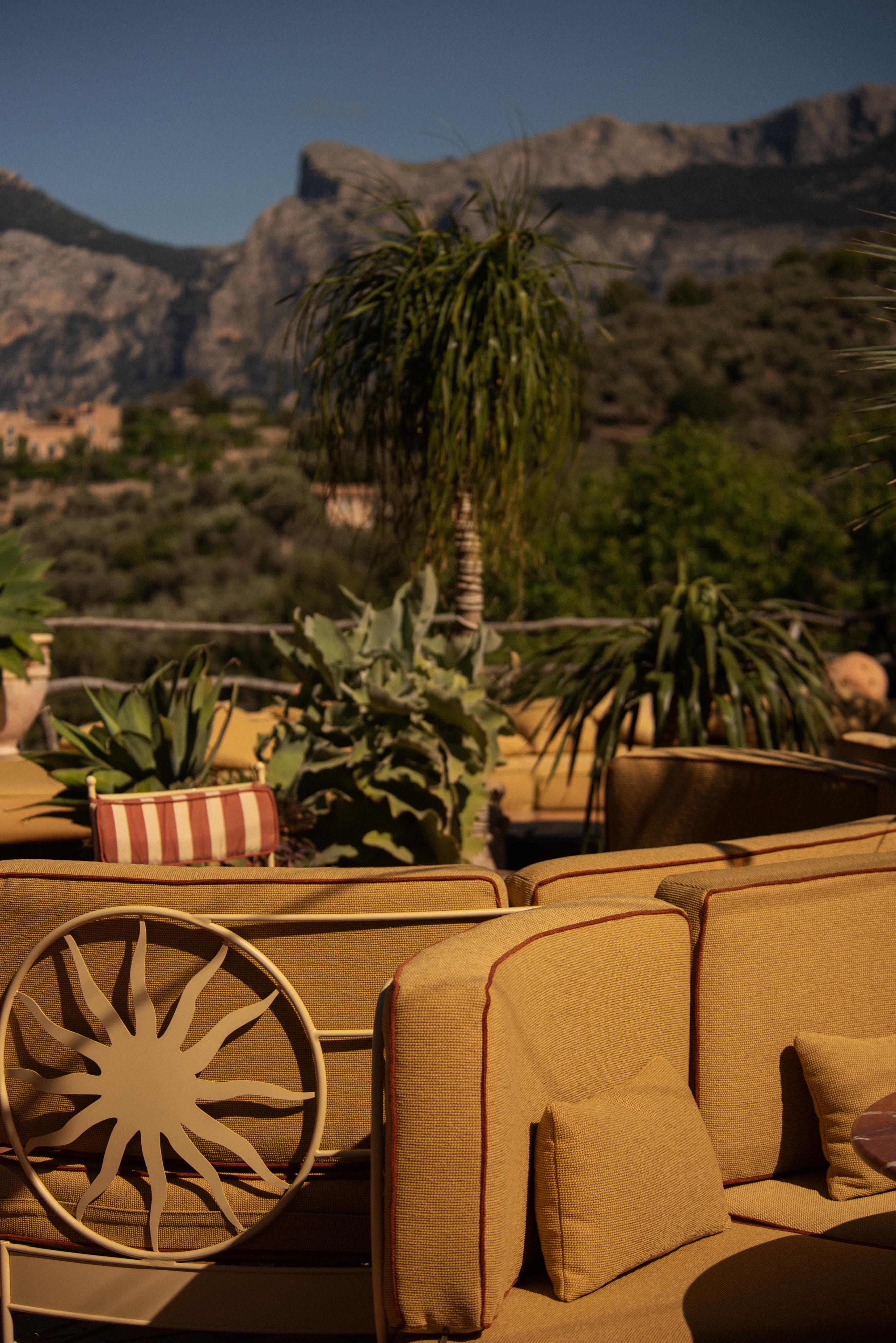 upholstered seating, tables and steel frame chairs on sunny terrace restaurant