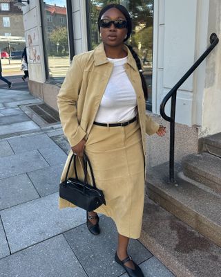 An influencer wears a yellow matching skirt set.