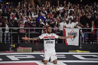 Dani Alves gets down on his knees and holds out his arms during his presentation as a Sao Paulo player in August 2019.