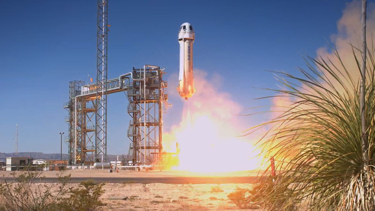 a white rocket launches into a blue desert sky