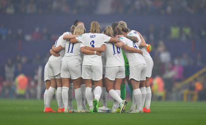 MANCHESTER, ENGLAND - JULY 06: The England team have a group huddle before the kick off of the UEFA Women&#039;s Euro England 2022 group A match between England and Austria at Old Trafford on July 6, 2022 in Manchester, United Kingdom. (Photo by Dave Howarth - CameraSport via Getty Images)