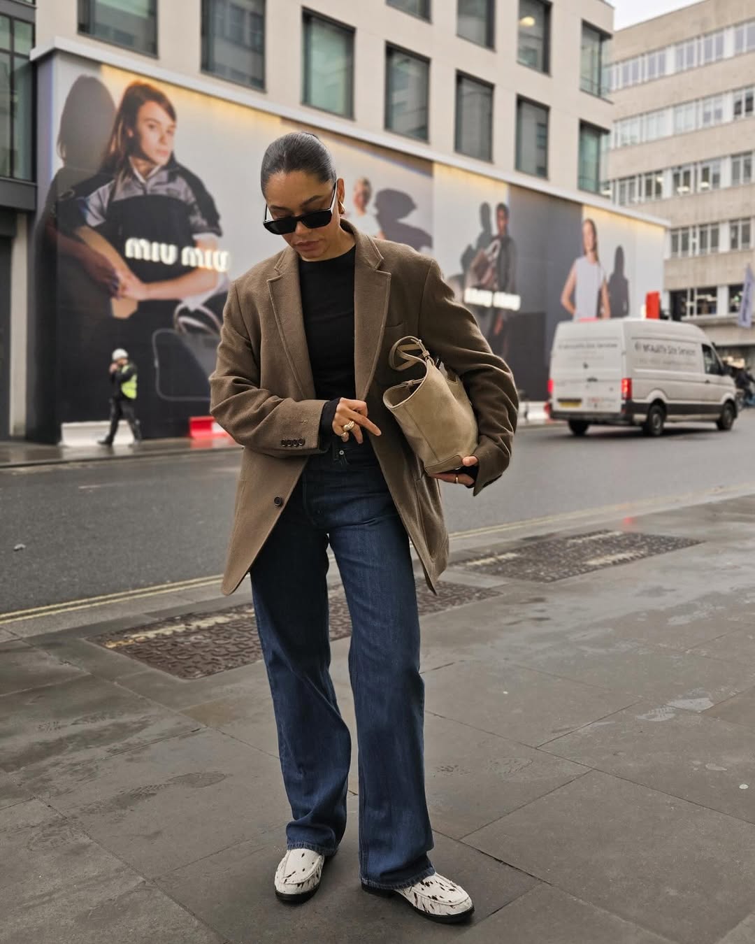 Influencer A Style Edit wearing straight jeans, a blazer and moccasins.