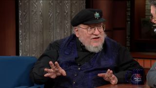 An image of George RR Martin talking to Stephen Colbert on his talk show.