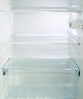 A clean empty refrigerator with glass shelves