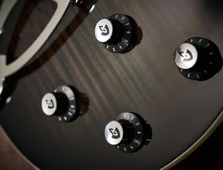 길드 리플렉터 손잡이는 정말 멋지다. 두 기타는 모두 픽업에 대한 독립적 인 볼륨 및 톤 컨트롤과 유사한 설정을 제공합니다-하지만 시간 볼륨 컨트롤에 코일 분할이 있습니다.