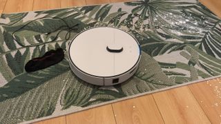 Samsung Bespoke Jet Bot Combo AI on a patterned rug, trying to pick up oats and cornflower