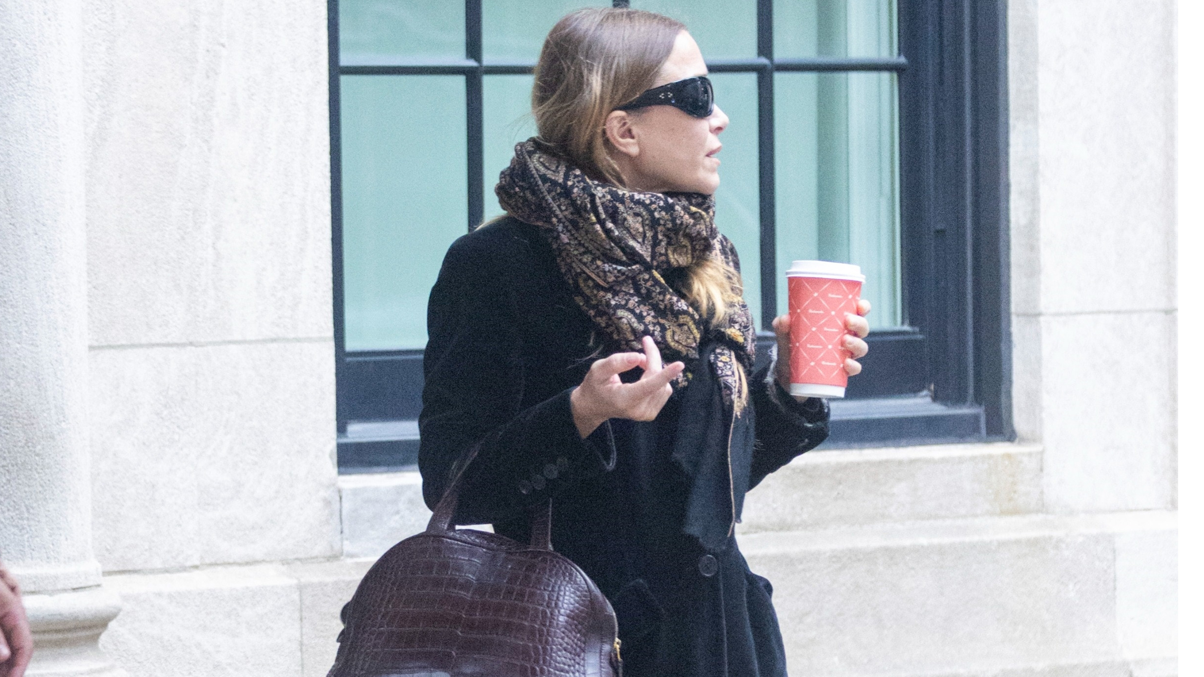 Mary-kate olsen wears a velvet coat, croc-effect brown bag, and a scarf.