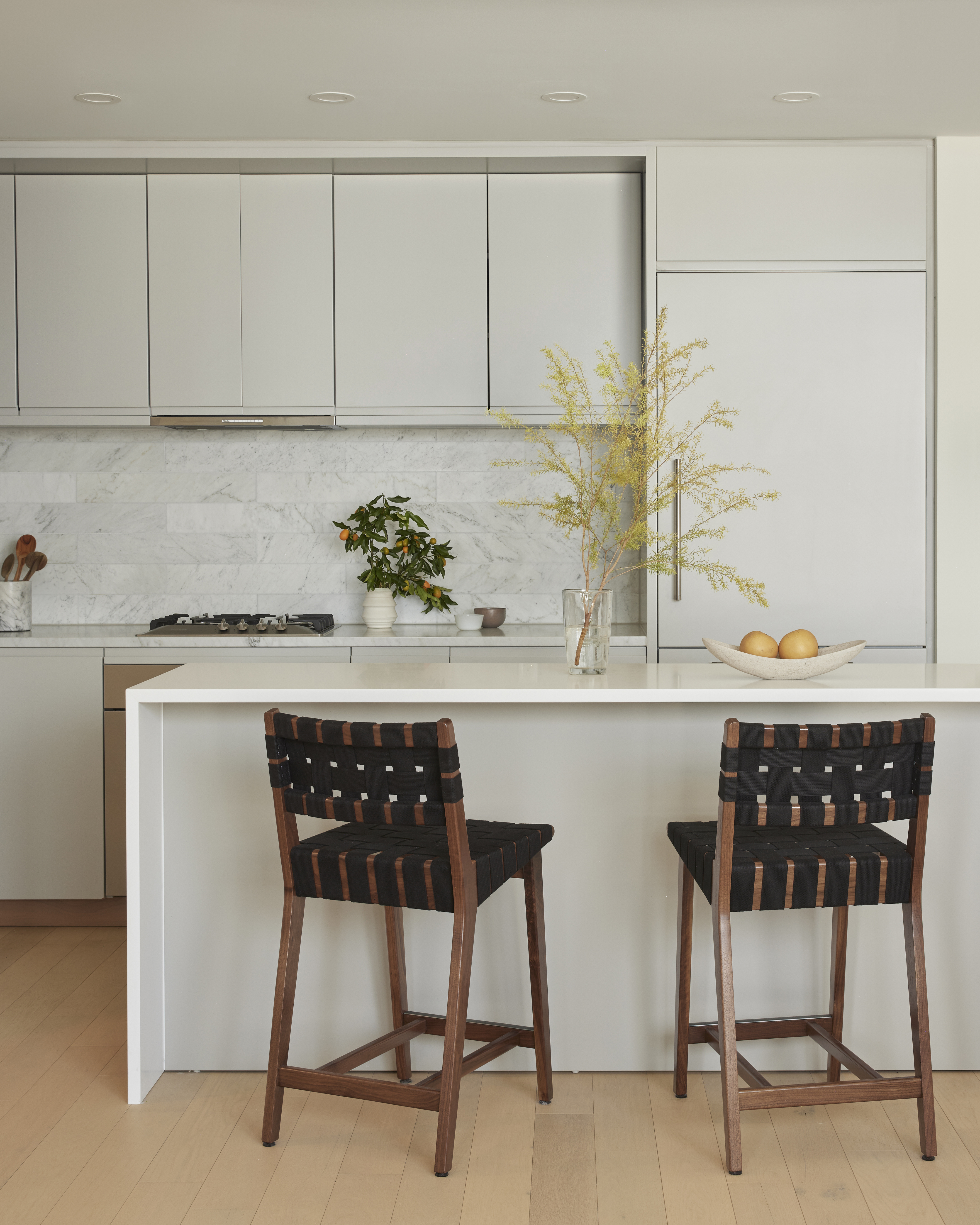 An all-white kitchen with spotlights in the ceiling