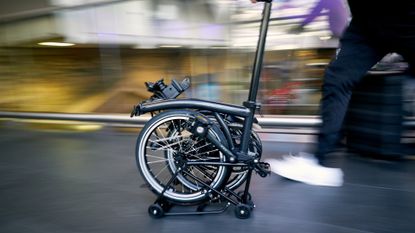 Brompton Electric P Line being wheeled through a station
