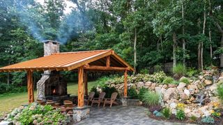 Outdoor seating area with stone fireplace and rock garden