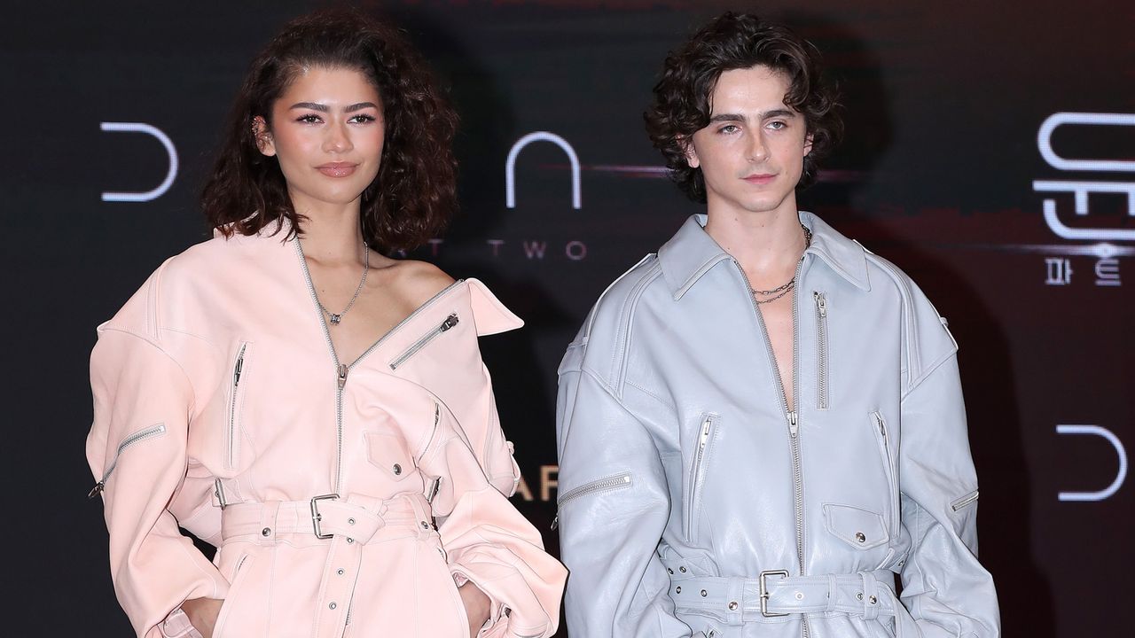 Zendaya and Timothee Chalamet wearing matching leather jumpsuits in pink and blue respectively