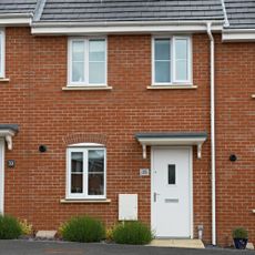 Front of modern red brick terraced home with white front door