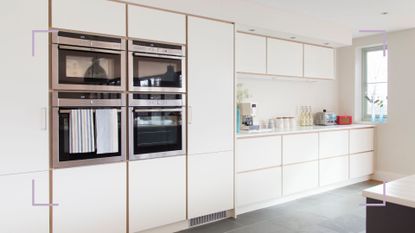 Cream kitchen with wall of cabinets and integrated appliances to show how to organize kitchen cabinets for a streamlined space
