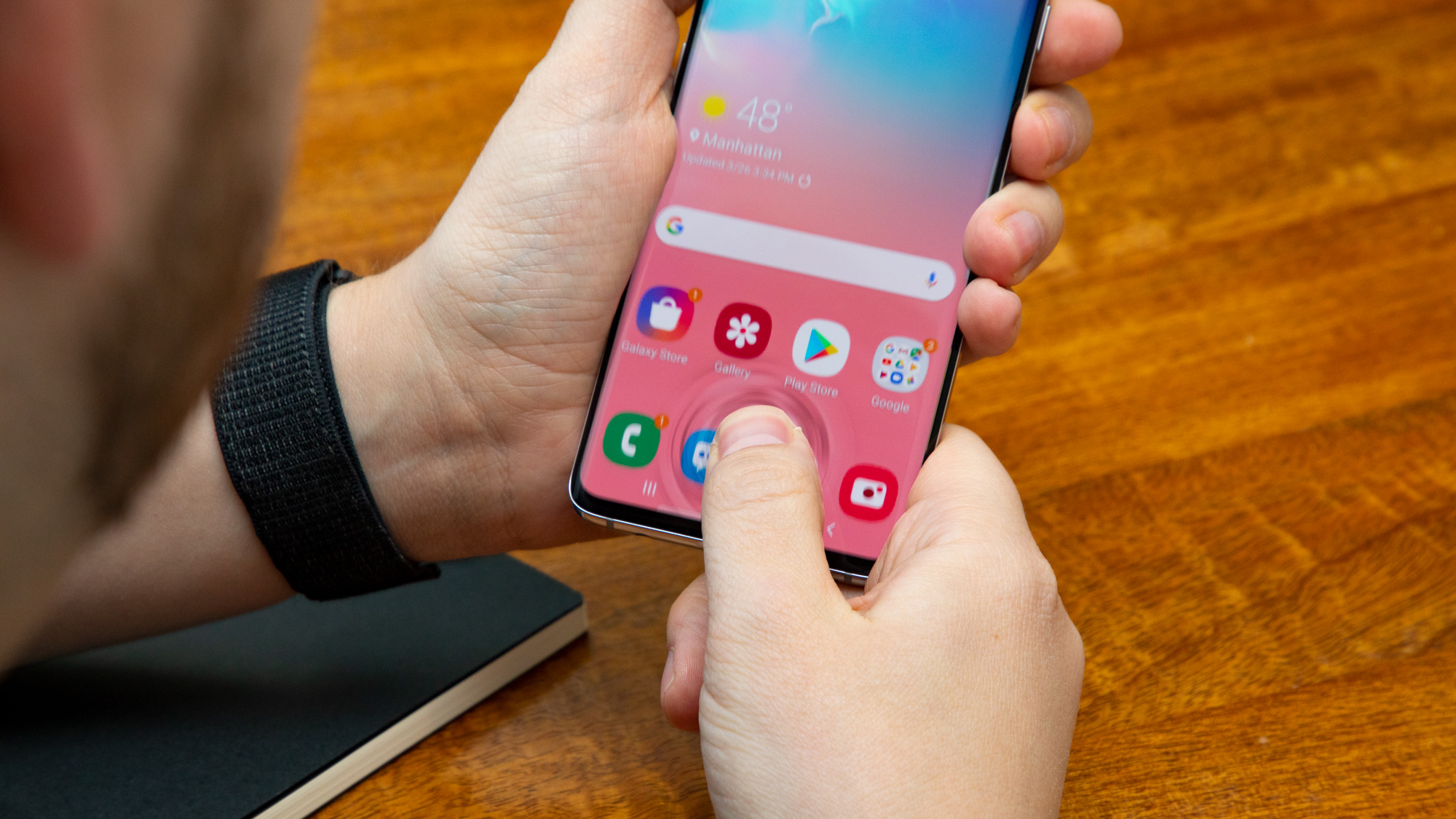 Someone placing their thumb on a Samsung Galaxy S10's screen
