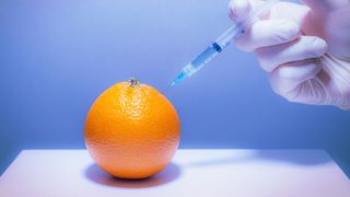 orange being injected with a food additive
