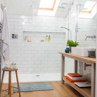 bathroom with shower on white tiled walls