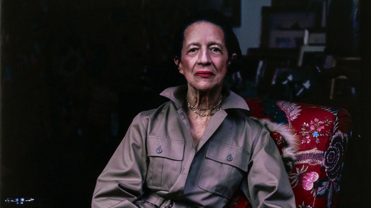 diana vreeland in a red chair on a black background