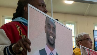 Activists hold signs showing Tyre Nichols