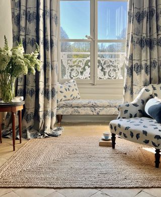 blue and white curtain with rush rug and side table