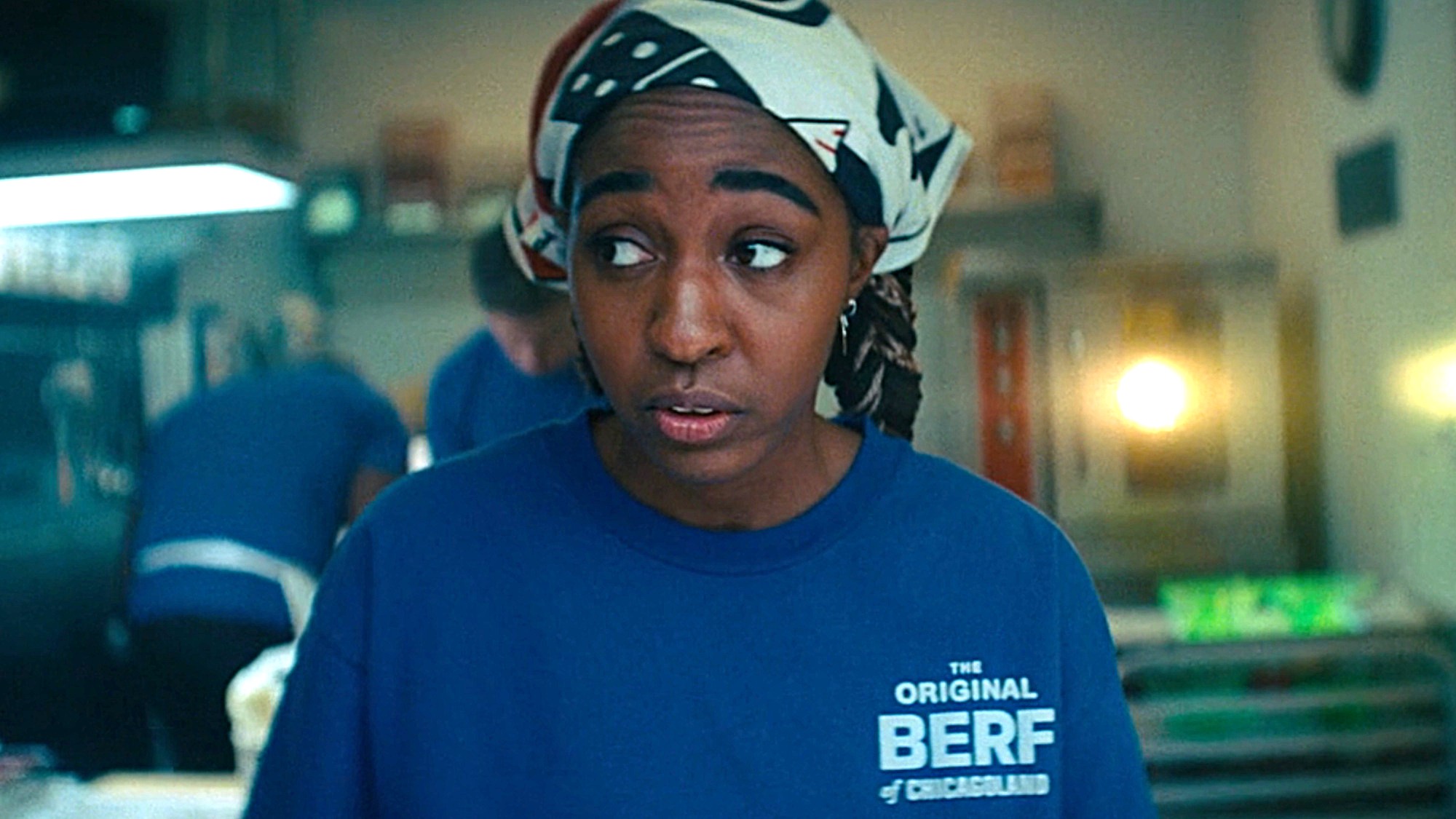 Sydney (Ayo Edebiri) wears a shirt that reads "The Original Berf of Chicagoland" on The Bear.