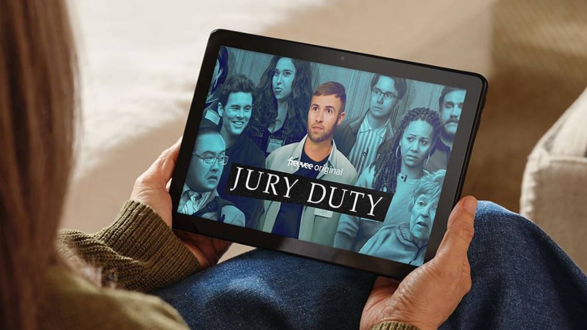 Amazon Fire HD 10 - woman holding Fire HD 10 watching Jury Duty 