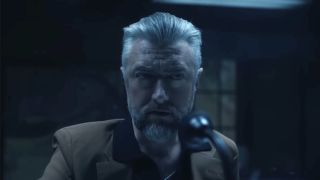 Sean Gunn's Maxwell Lord looking at Peacemaker during "job" interview