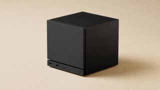 Black Steam Machine PC with beige backdrop.