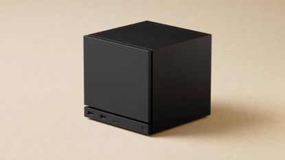 Black Steam Machine PC with beige backdrop.