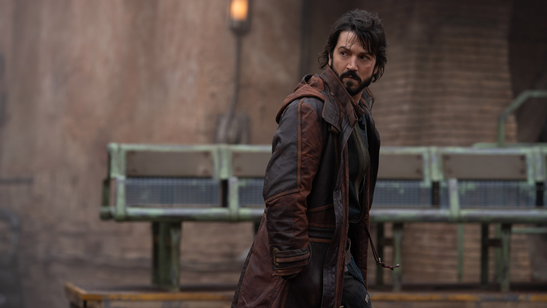 Cassian Andor mira hacia atrás mientras camina por la ciudad principal de Ferrix en Andor en Disney Plus