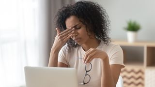 A woman looking stressed while sitting in front of laptop