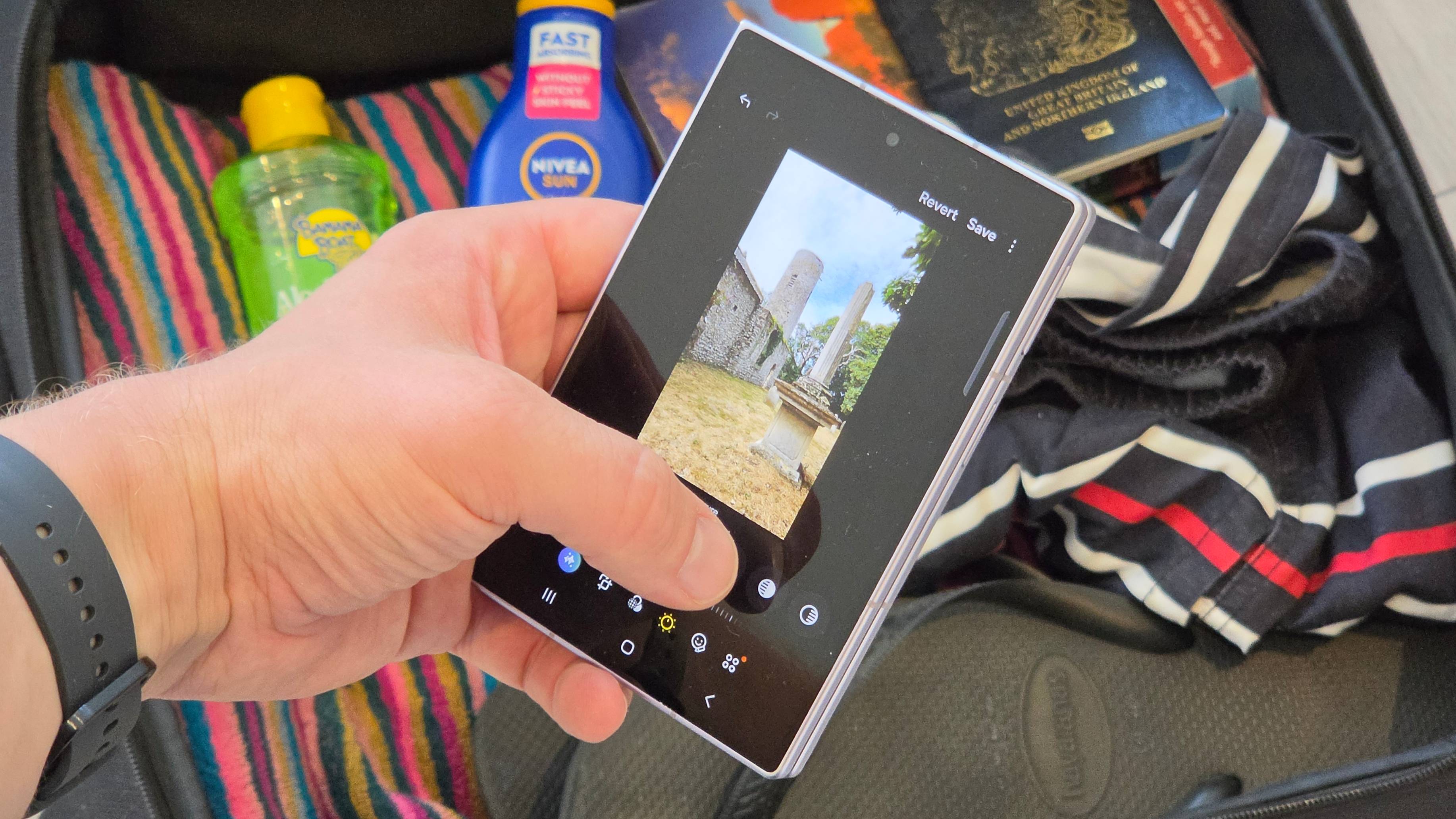 The Samsung Galaxy Z Fold 8, on a photo editing page, above a packed suitcase.