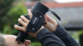 Someone using a pair of binoculars to look at the sky.